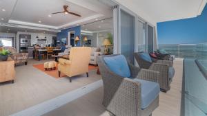 a living room with wicker chairs and a dining room at Encantame Towers Verano 1401 in Puerto Peñasco