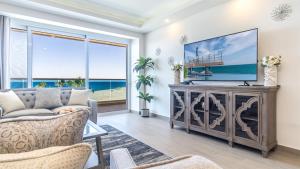 a living room with a couch and a tv at Encantame Towers Viento 304 in Playa Encanto