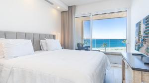 a bedroom with a large bed with a view of the beach at Encantame Towers Viento 304 in Playa Encanto +22 photos