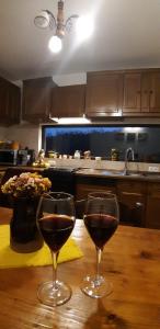 dos copas de vino en una mesa de madera en una cocina en Bucovina Sky View, en Gura Humorului