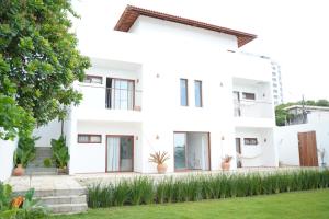 a white facade of a house with potted plants at Casa Aia - Hospedagem de Charme na Atalaia in Aracaju +46 photos