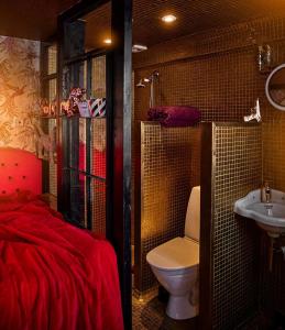 a bathroom with a bed and a toilet and a sink at Revolverhotel in Visby
