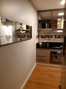 a kitchen with stainless steel appliances and wooden floors at Flat particular Vision Executive in Brasília