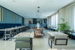 a dining room with tables and chairs and windows at C07- Pestana - Luxury Hotel Flat - Terrace - Pool in Casablanca