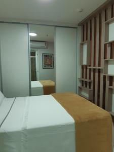 a bedroom with a white bed and a mirror at Flat particular Vision Executive in Brasília +22 photos