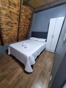 Cette petite chambre comprend un lit avec des draps blancs. dans l'établissement Cabana da Praia, à Rio Grande