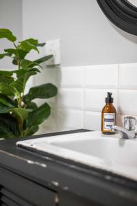 a bottle of soap sitting on a bathroom sink at City Oasis Suite Cape Town in Cape Town