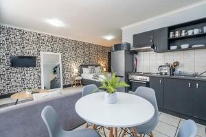 a kitchen and dining room with a white table and chairs at City Oasis Suite Cape Town in Cape Town