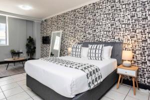 a bedroom with a large bed and a brick wall at City Oasis Suite Cape Town in Cape Town +7 photos