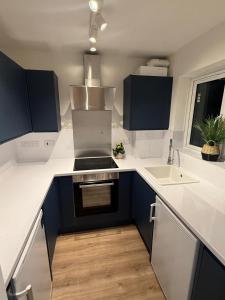 Crown Residency London في لندن: مطبخ به كونترات سوداء وبيضاء ومغسلة