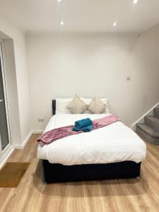 Crown Residency London في لندن: غرفة نوم بسرير كبير مع ملاءات بيضاء