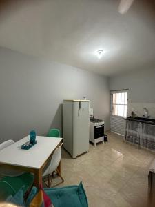 a kitchen with a refrigerator and a table in a room at Casa Vale da Paz - Massaguaçu. in Caraguatatuba