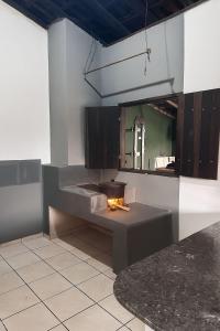 a kitchen with a fire pit and a mirror at Chalé Moinho Localização Privilegiada em Carrancas - MG in Carrancas +5 photos