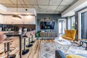 a kitchen and living room with a bar and chairs at Appartement Luxe, Incredible Sunset View, Pool, Parking, Near Old Québec in Quebec City