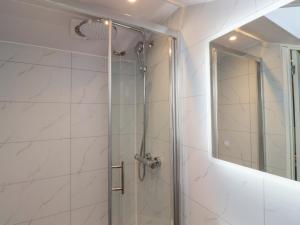 a shower with a glass door and a mirror at Nobles Nook in Seahouses +18 photos