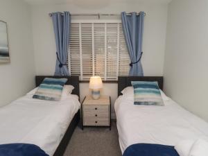 two twin beds in a room with a window at Nobles Nook in Seahouses