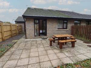 a picnic table and bench in front of a house at Nobles Nook in Seahouses