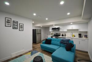 a living room with a blue couch and a kitchen at Guest Suite with Private Entry in Calgary in Calgary