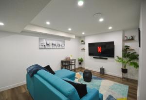 a living room with a blue couch and a flat screen tv at Guest Suite with Private Entry in Calgary in Calgary