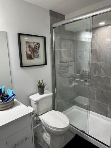 a bathroom with a toilet and a glass shower at Guest Suite with Private Entry in Calgary in Calgary