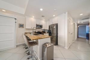 a kitchen with white cabinets and a granite counter top at 1BR 1BA Ocean View Las Palomas Phase 1 Bld Ruby in Puerto Peñasco