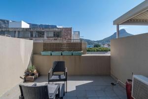 a balcony with chairs and a view of a building at City Light & Mountain Sight in Cape Town