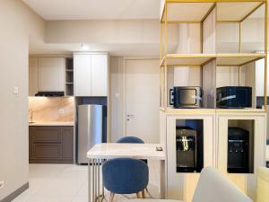 a kitchen with a table and two blue chairs at La Vida II at Anderson Tower in Surabaya