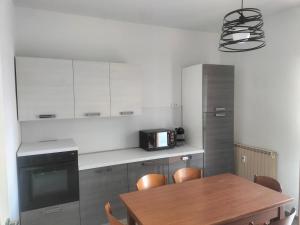 a kitchen with a wooden table and a microwave at Appartamento Muscatel in Piobesi dʼAlba