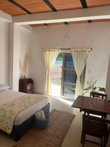 CoveñitasにあるIsla Rosa Coveñas - Alojamientoのベッドと机と窓のある寝室