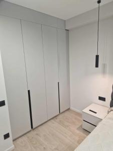 a room with white cabinets and a bed and a table at ZEN home in Chişinău