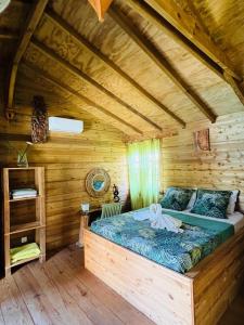 a bedroom with a bed in a wooden cabin at les gites du cocon in Sainte-Rose
