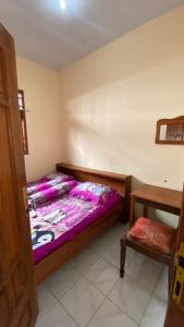 a bedroom with a wooden bed and a table at Homestay Rengganis Tengger in Ngadisari