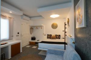 a bedroom with a bed and a couch in a room at Double M Adults Only in Ano Mera