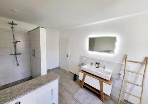 Un baño blanco con lavabo y espejo. en Mountain Apartments Leutkirch, en Leutkirch im Allgäu 27 fotos más