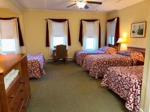 une chambre d'hôtel avec quatre lits et une table dans l'établissement Silver Bay YMCA Inn and Conference Center, à Silver Bay