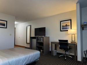 a hotel room with a bed and a desk with a computer at Quality Inn in West Des Moines