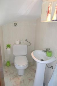 a white bathroom with a toilet and a sink at Apartamento Santa Cruz in Santa Cruz