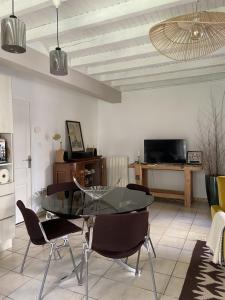 a living room with a glass table and chairs at Le jardin du Griffoul in Nébias