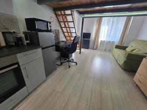 a kitchen and living room with a couch and a table at Studio cosy avec mezzanine & parking 2min Walibi in Les Avenières +4 photos