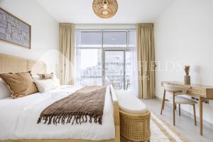 um quarto com uma cama, uma escrivaninha e uma janela em Bloomfields Spacious 2br in Lamar Raha em Al Qurayyah