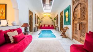 sala de estar con sofá rojo y piscina en Riad Dar Lghizlane, en Marrakech