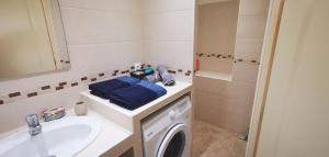 a bathroom with a washing machine and a sink at Studio cosy avec mezzanine & parking 2min Walibi in Les Avenières