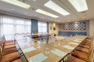 une grande salle de conférence avec une longue table et des chaises dans l'établissement Hotel Puertollano, à Puertollano