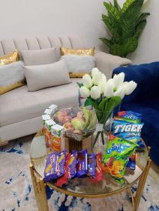 - une table basse avec des collations et un vase de fleurs dans l'établissement Moonlight golf view, au Caire