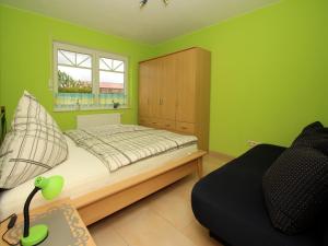 - une chambre avec des murs verts, un lit et une armoire dans l'établissement Apartment house at Kiessee, Westerholt, à Westerholt