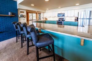 a kitchen with a bar with stools at Hot Tub & Game Room in Large Ocean Front Home! Second Story in Holiday Beach