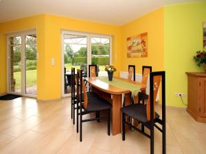WesterholtにあるApartment house at Kiessee, Westerholtの黄色の壁のダイニングルーム(木製のテーブルと椅子付) +22枚の写真
