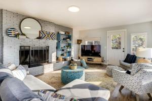 Ocean Front with Spectacular Views! 2 Bedroom, 2 Bath! Seal Rock Cottage! في Seal Rocks: غرفة معيشة مع أريكة ومدفأة