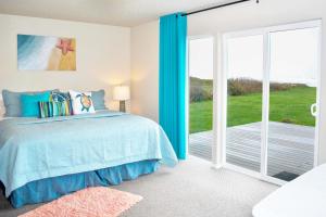 een slaapkamer met een bed en een glazen schuifdeur bij Ocean Front, Amazing Views! Hot Tub! Sandy Seclusion in San Marine