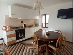 a kitchen with a wooden table and a table and chairs at Cà Giaculn in Muriaglio